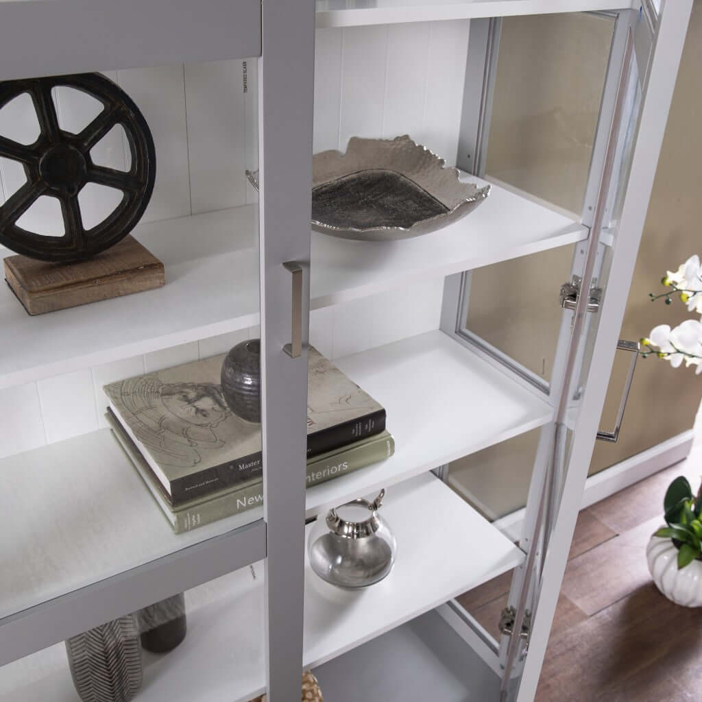 Gray double door curio cabinet displaying decorative items, books, and collectibles with elegance.