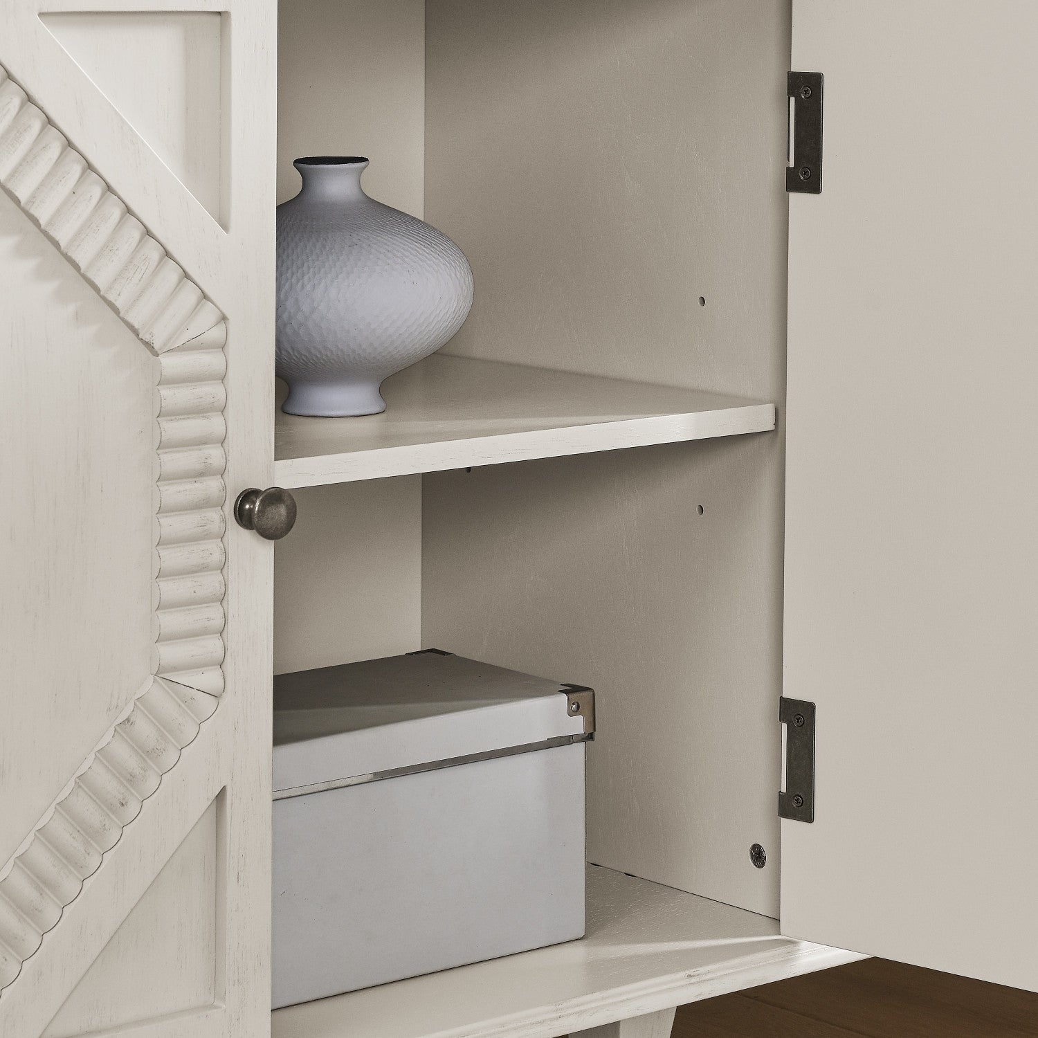 Interior view of HOMEROOTS White Wood Accent Cabinet with Doors & Shelves showing a vase and a box.