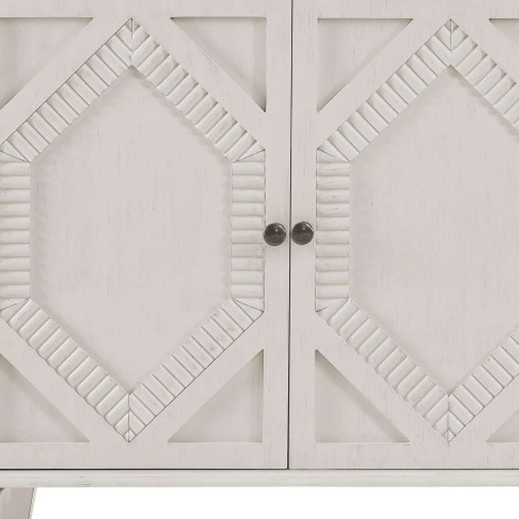 Close-up of the intricate geometric carvings on the HOMEROOTS White Wood Accent Cabinet with Doors & Shelves.